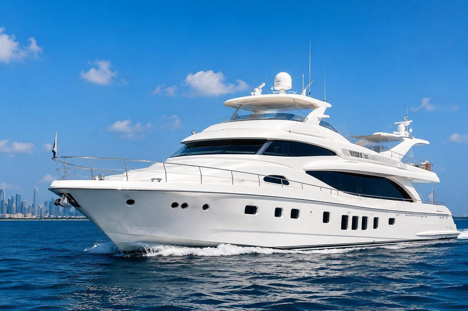 A white motor yacht on calm blue water off the Dubai coast